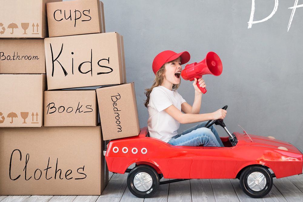 Child New Home Moving Day House Concept Happy child playing into new home. Kid having fun indoor.