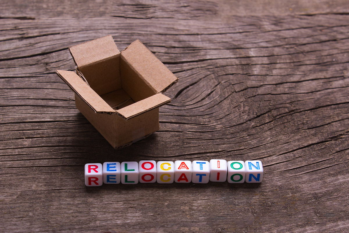 Moving to another office or house. Word relocation on an old wooden background